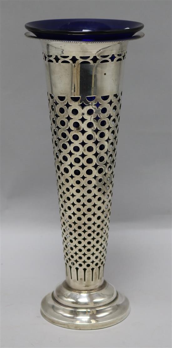 A George V pierced silver trumpet vase, C.W. & S, Birmingham, 1911, with blue glass liner, 6.5 oz.